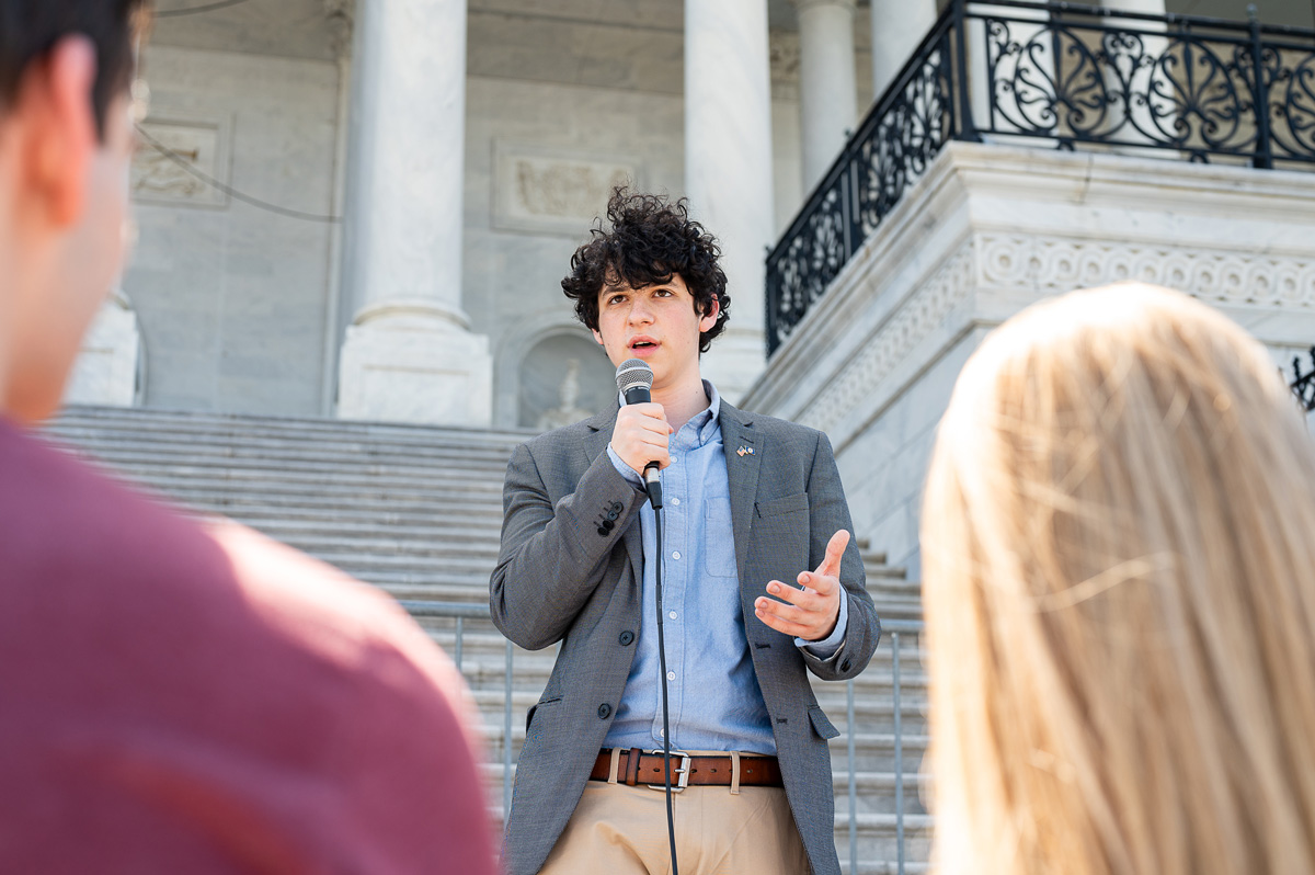 Aaron Rafael Zevin-Lopez speaking on stairs to a group