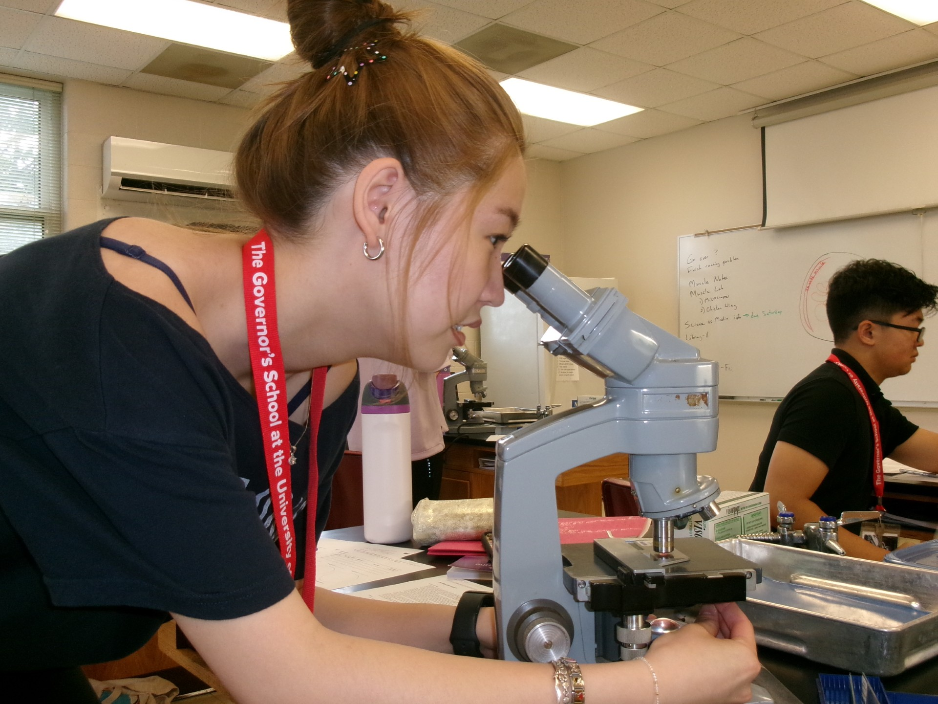 student looking through a microscope